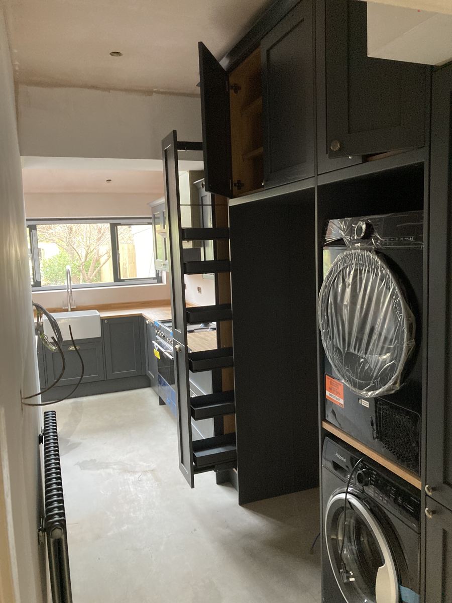 Full-height pull-out larder extended, showing black storage racks