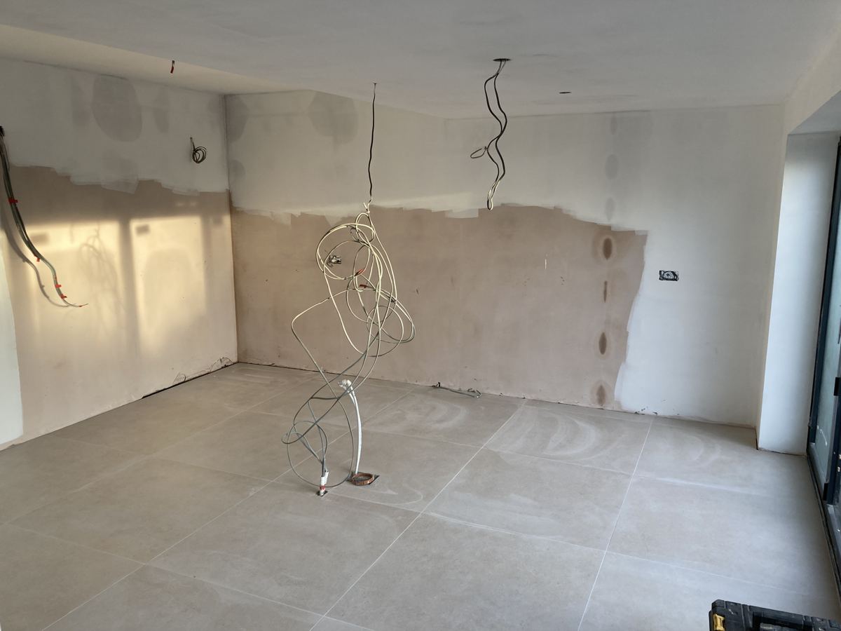 The empty, newly plastered open-plan space before kitchen installation
