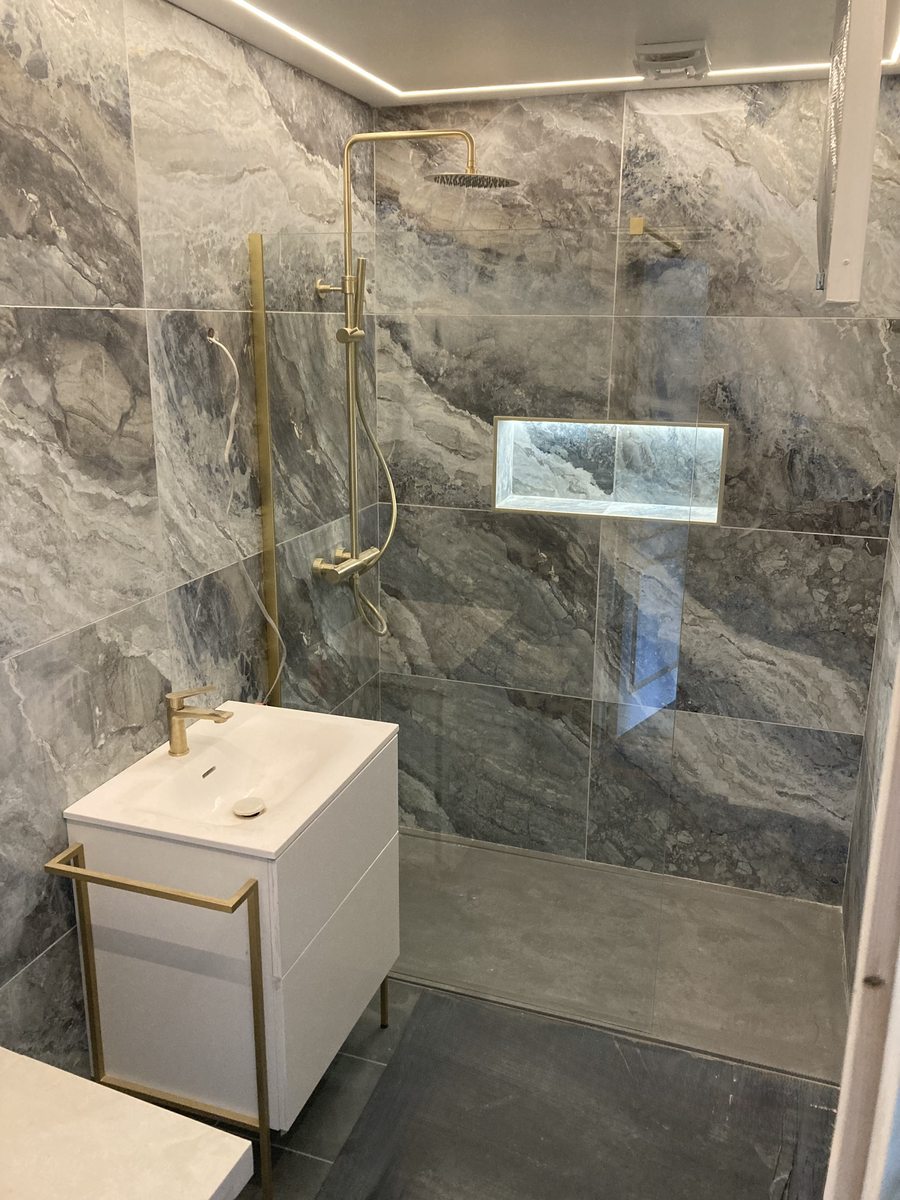 Marble tiled en suite with gold fixtures — Fitted Homes Cardiff