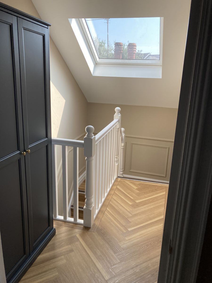 Oak staircase with panelled walls and herringbone flooring — Fitted Homes