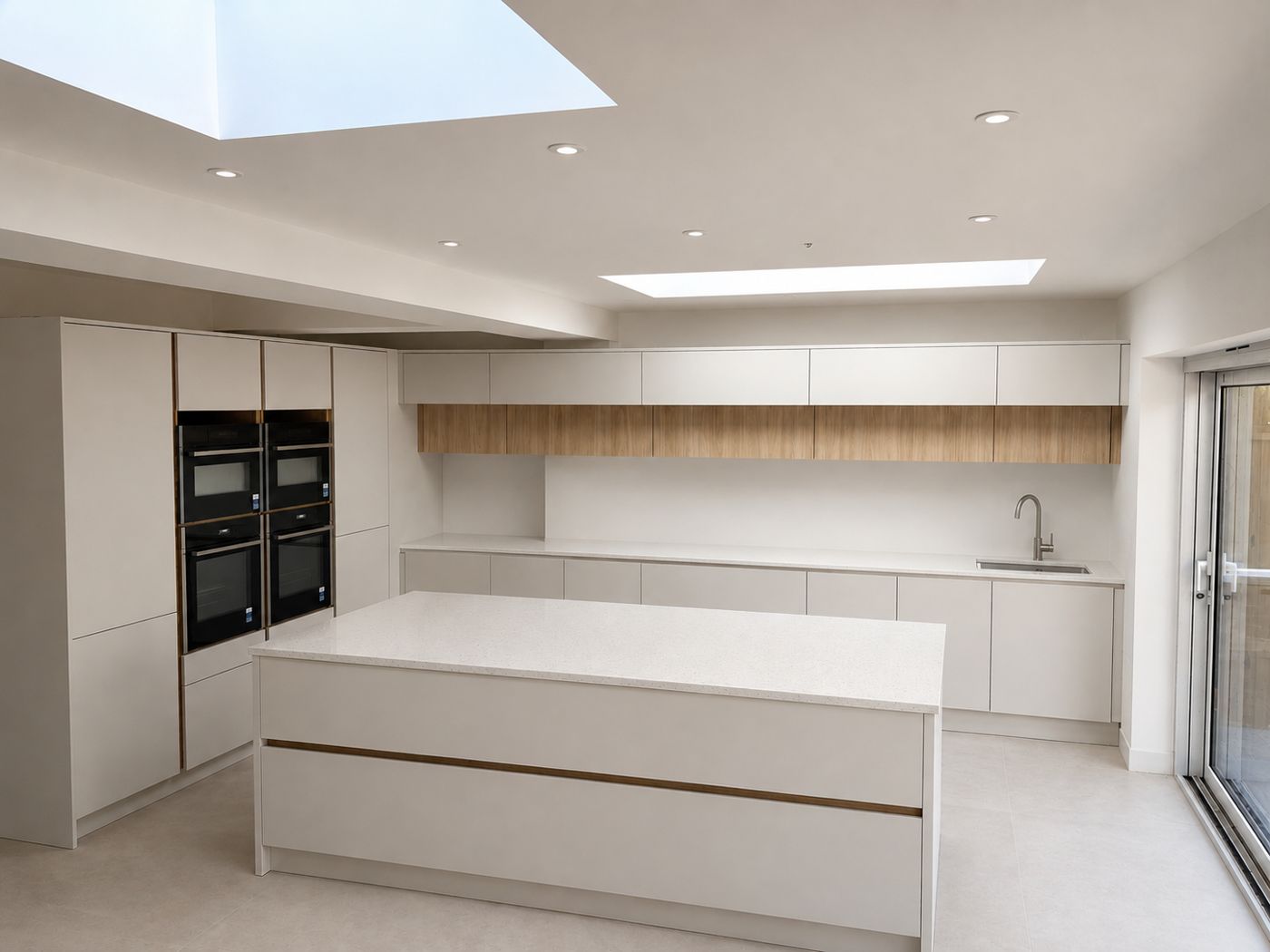 White handleless kitchen with oak accents, island and skylights — Fitted Homes Cardiff