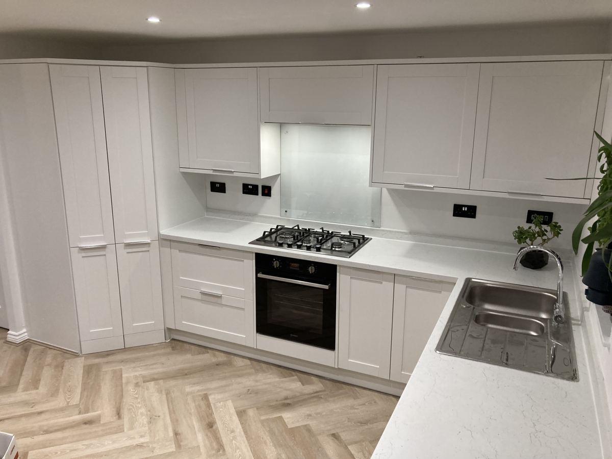 Finished kitchen corner with sink, marble-effect worktops and herringbone floor