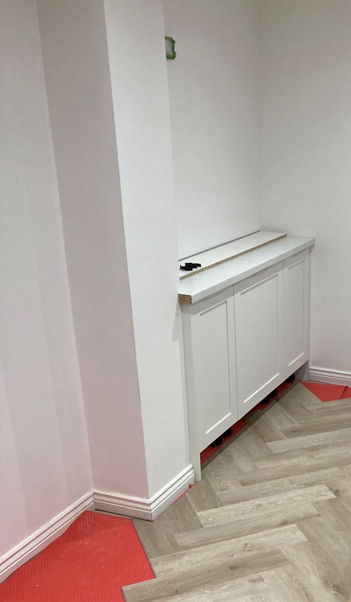 Herringbone flooring laid around new fitted cabinetry surrounds