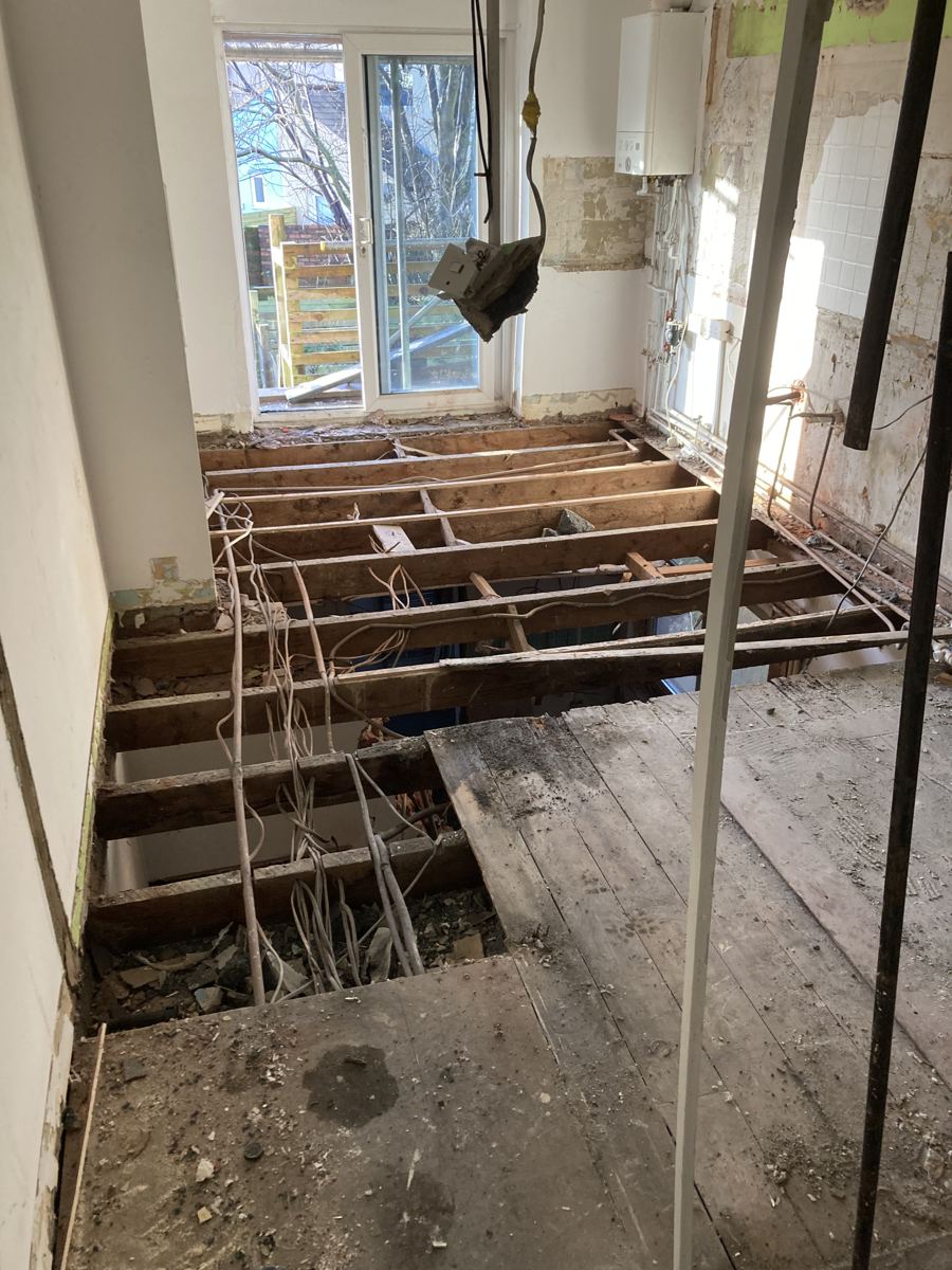 The old kitchen floor opened up, showing rotten joists above the flat below